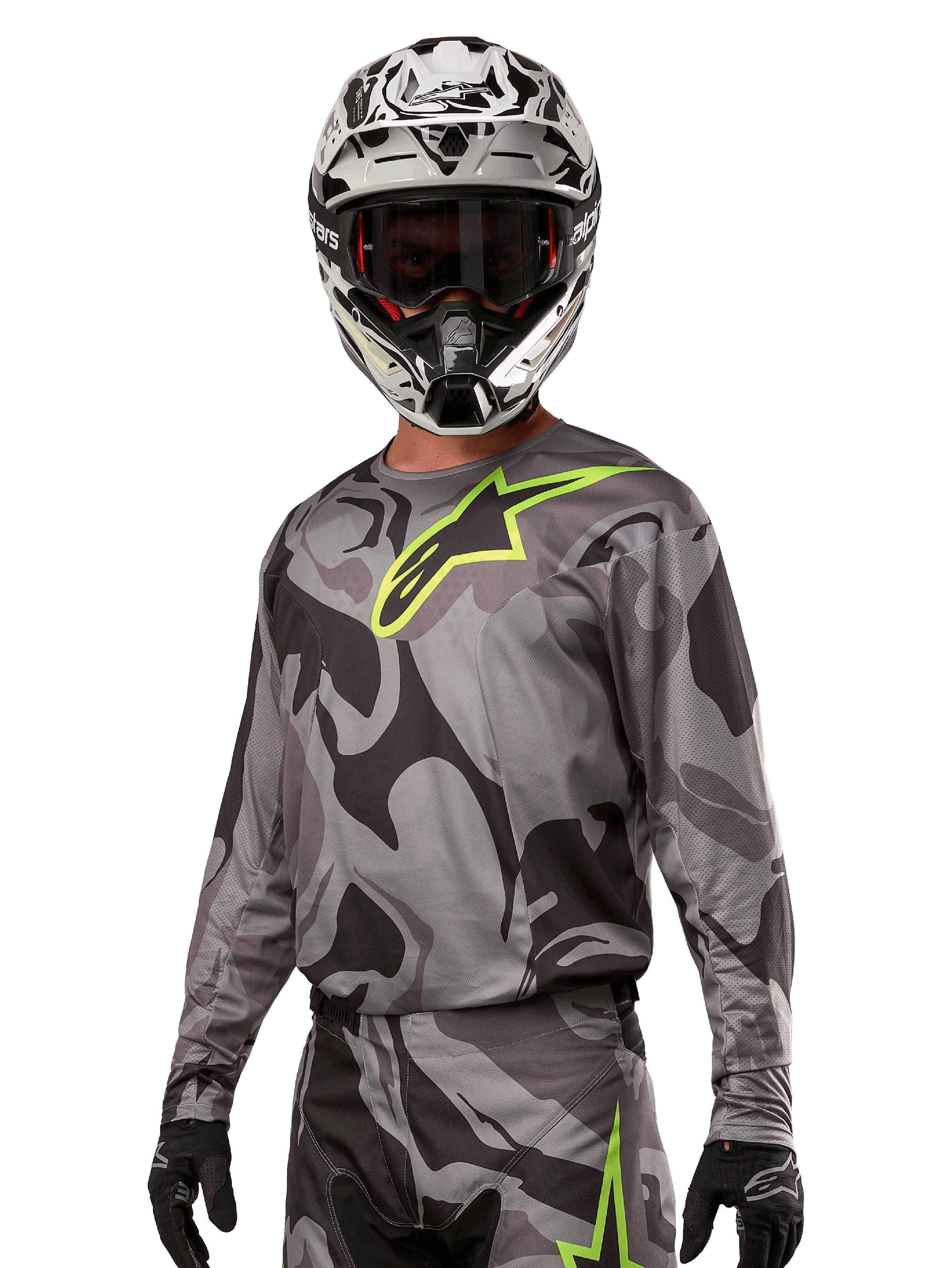 Alpinestars 2024 Racer Tactical Jersey, jersey de motocross, camuflaje Cast Gray Camo Magnet con logo verde neón, usado con casco blanco y negro y guantes negros, tejido técnico que absorbe la humedad para carreras fuera de carretera