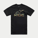 A person stands facing forward, wearing the Alpinestars Ride 4.0 Camo CSF Tee. The black T-shirt features a soft hand print with a colorful graphic logo and the word "RIDE" beneath. The person has short hair and a neutral expression. The background is plain black.