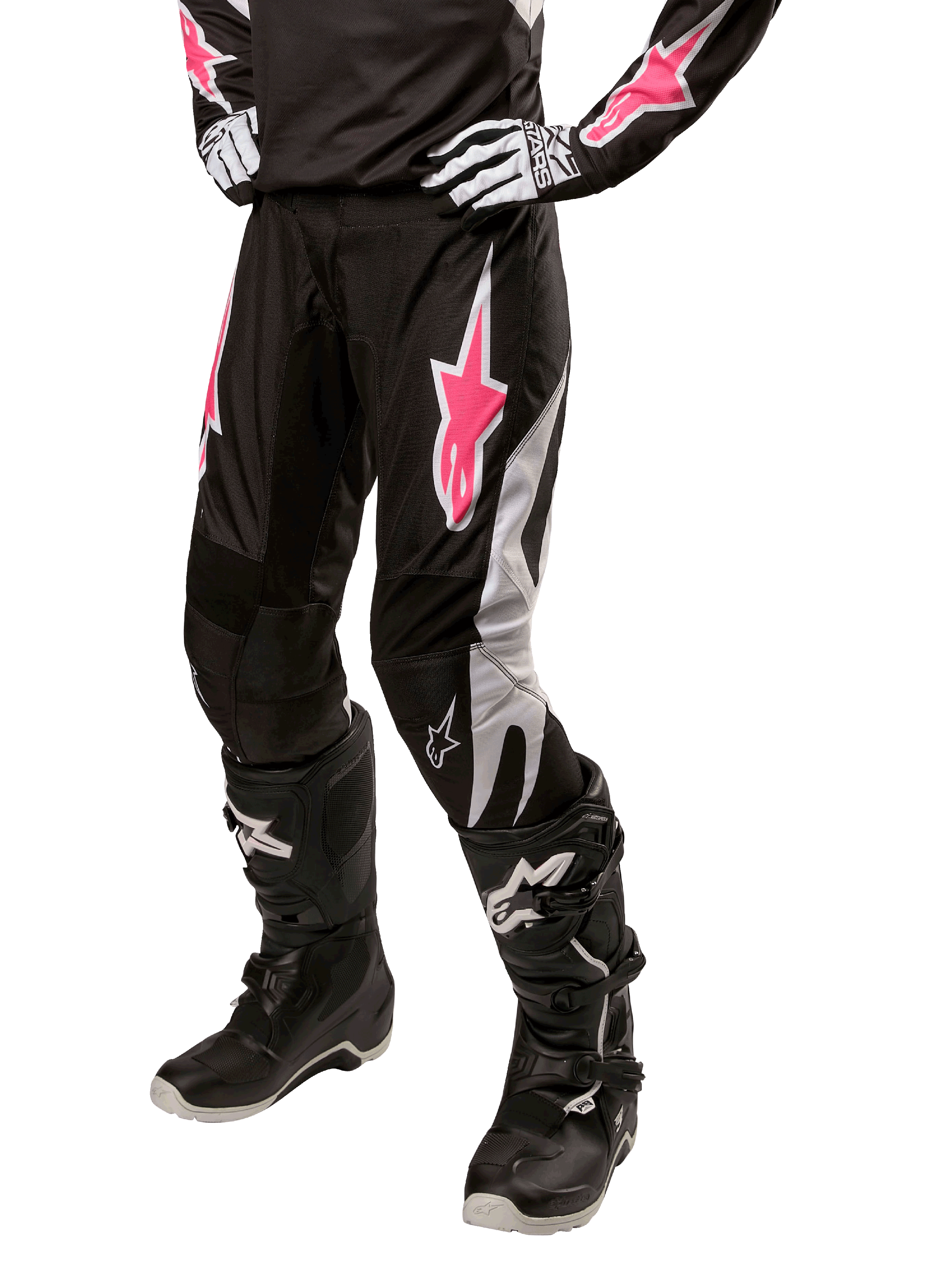 Alpinestars Stella Fluid Pant 2024 para mujer, pantalones de motocross negros y blancos con detalles en rosa, combinados con equipo de protección a juego, incluyendo botas y guantes, tejido duradero y flexible para conducción fuera de carretera
