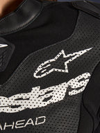 Primer plano del traje de cuero de 2 piezas Alpinestars Stella GP-R7 en color negro, con paneles de cuero perforado, un gran logotipo blanco de Alpinestars en el pecho y secciones de tejido elástico transpirable.