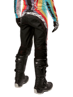 Alpinestars Stella Techstar Pants 2024 para mujer, pantalones de motocross, negro multicolor, vista trasera con marca blanca destacada en el asiento, combinados con botas Tech 3 negras y un jersey multicolor a juego, equipamiento profesional de carreras todoterreno