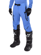 Alpinestars 2024 Supertech Dade Pants, pantalones de motocross, azul claro con logotipos gráficos en negro, con perforaciones de ventilación y hebilla magnética en la cintura, combinados con botas y guantes técnicos negros, equipo profesional de carreras todoterreno