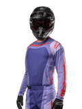 Alpinestars Techstar Ocuri Jersey 2024, jersey de motocross de manga larga, morado y naranja intenso, con perforaciones láser para ventilación y ajuste deportivo, usado con casco de motocross y guantes negros