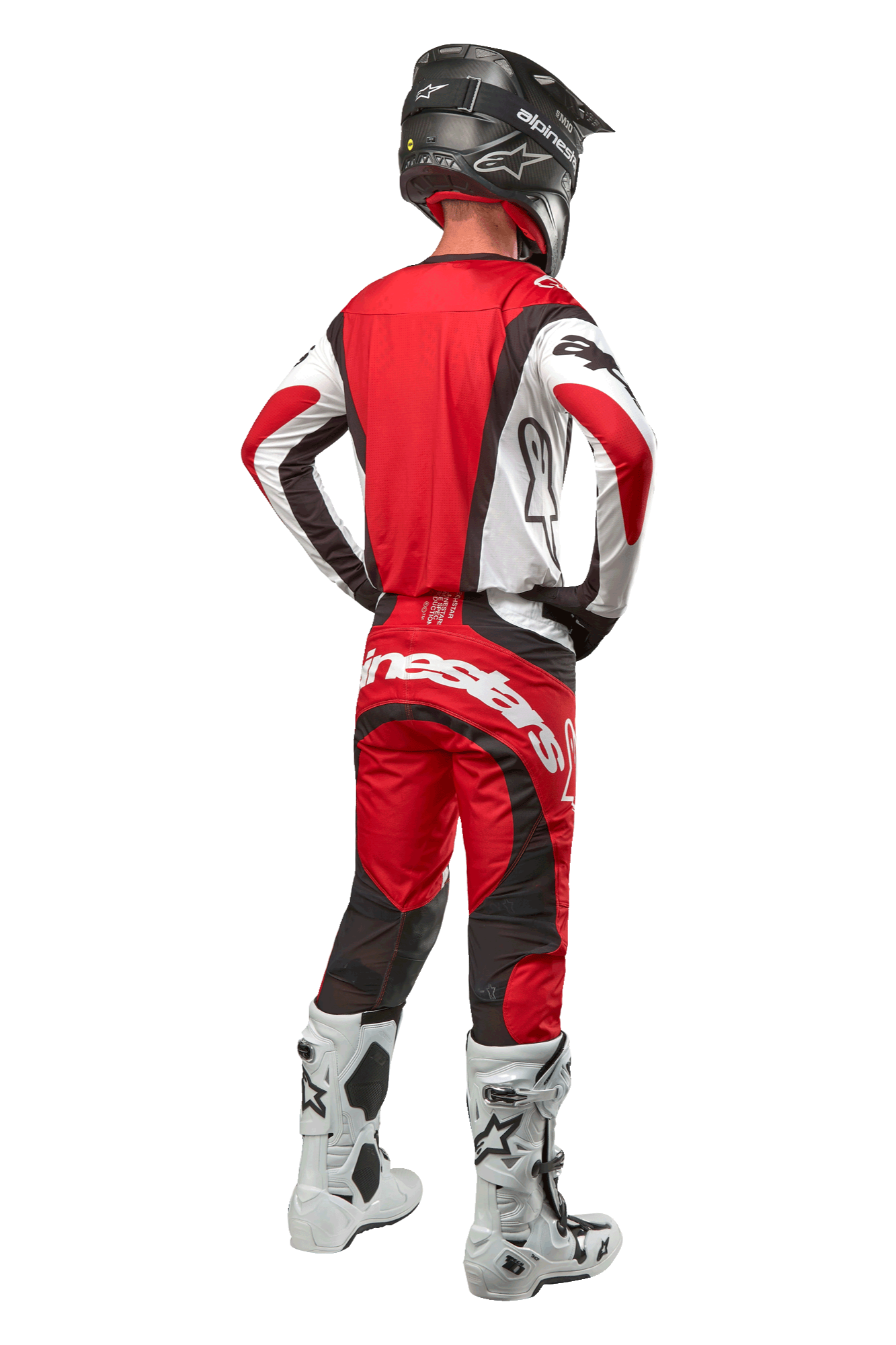 Alpinestars 2024 Techstar Ocuri Pants, pantalones de motocross, Rojo Marte Blanco Negro, vista trasera de un piloto de motocross con equipo completo de competición, incluyendo jersey a juego, casco negro y botas blancas y negras, resaltando la marca Alpinestars y la construcción de tejido duradero.