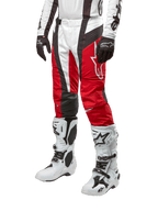 Alpinestars Techstar Ocuri Pants 2024, pantalones de carreras de motocross, rojo Marte, blanco y negro, usados con camiseta blanca y negra a juego, guantes negros y botas de carreras blancas con hebillas, equipo de protección técnica mostrado sobre un fondo blanco.