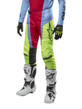 Alpinestars 2024 Techstar Ocuri Pants, pantalones de motocross en azul claro, rojo y amarillo neón, combinados con equipo a juego y botas blancas, con logotipos de Astars llamativos y un ajuste de competición.