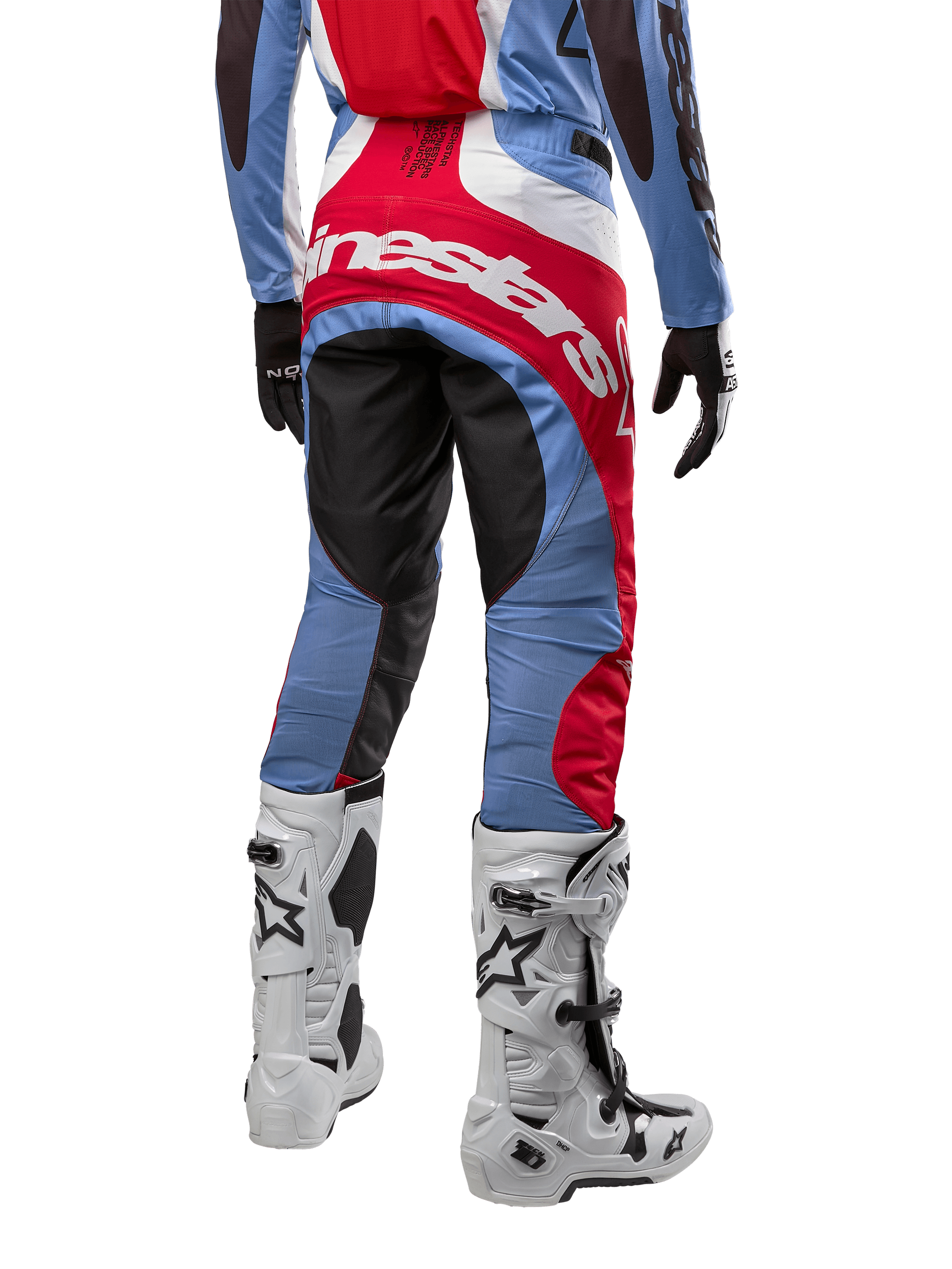 Pantalones Alpinestars Techstar Ocuri 2024, pantalones de motocross, azul claro, rojo Marte y blanco, vista trasera destacando el gran logotipo rojo de Alpinestars en el asiento, combinados con botas de carreras blancas y jersey a juego.