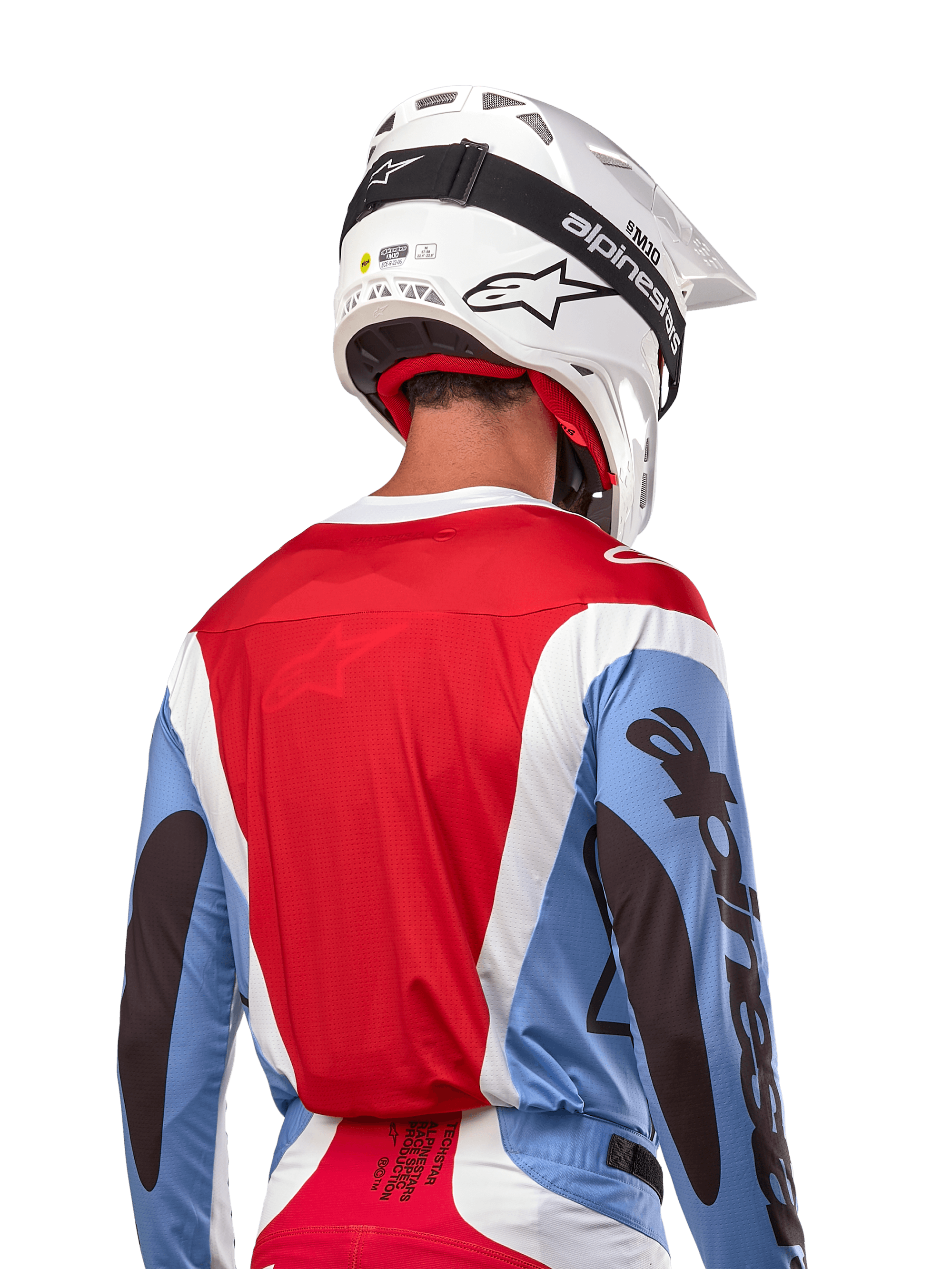 Alpinestars 2024 Techstar Ocuri Jersey, jersey de motocross, azul claro, rojo Marte y blanco, vista trasera del piloto con casco blanco a juego y gafas negras, con marca negra llamativa en las mangas y ajuste de carrera ergonómico para rendimiento todoterreno.
