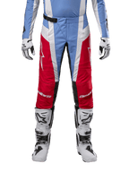 Alpinestars 2024 Techstar Ocuri Pants, pantalones de motocross, azul claro, rojo Marte y blanco, vista frontal desde la cintura para abajo, combinados con botas y guantes de motocross en blanco y negro, equipamiento técnico diseñado para competición off-road de alto rendimiento.