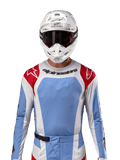 Alpinestars Techstar Ocuri Jersey 2024, jersey de motocross, azul claro, rojo Mars y blanco, vista frontal con ventilación cortada por láser y ajuste atlético, usado con casco blanco y gafas para un look profesional de competición off-road