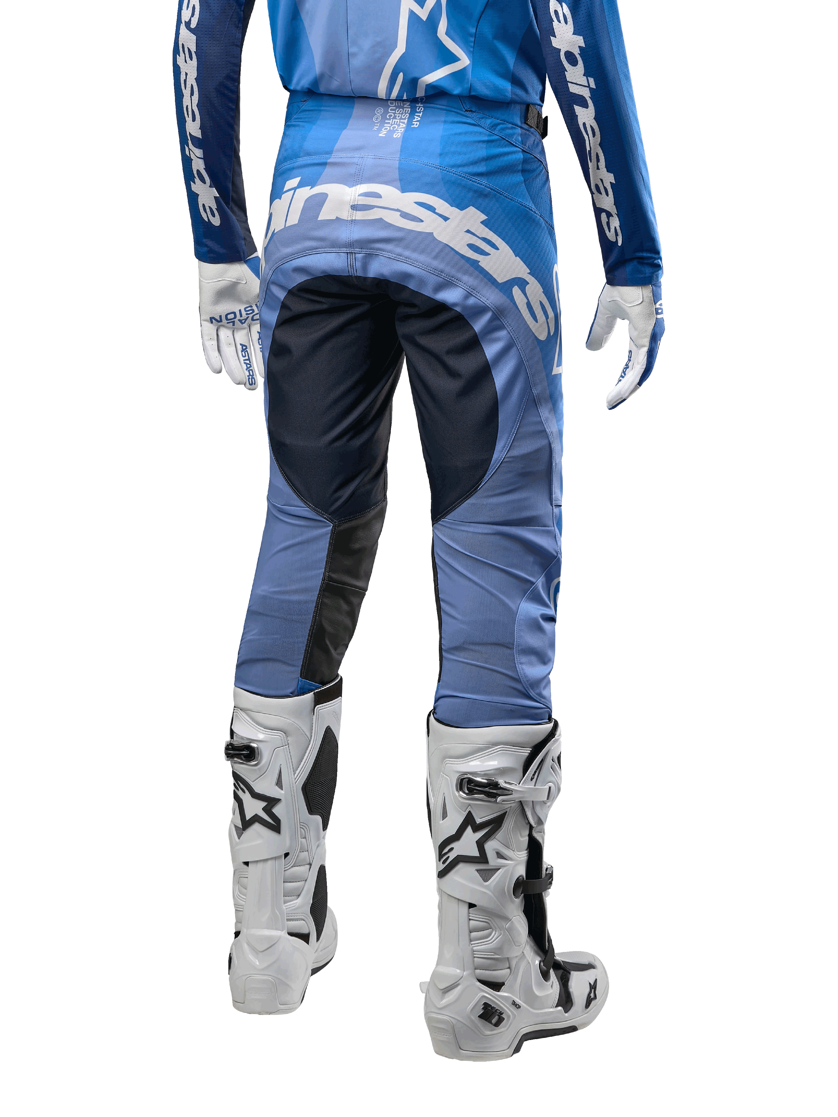 Alpinestars Techstar Pneuma Pants 2024, pantalones de motocross, azul marino y azul claro, vista trasera con logotipo blanco llamativo en el asiento y paneles negros reforzados, combinados con botas de motocross Tech 10 blancas.