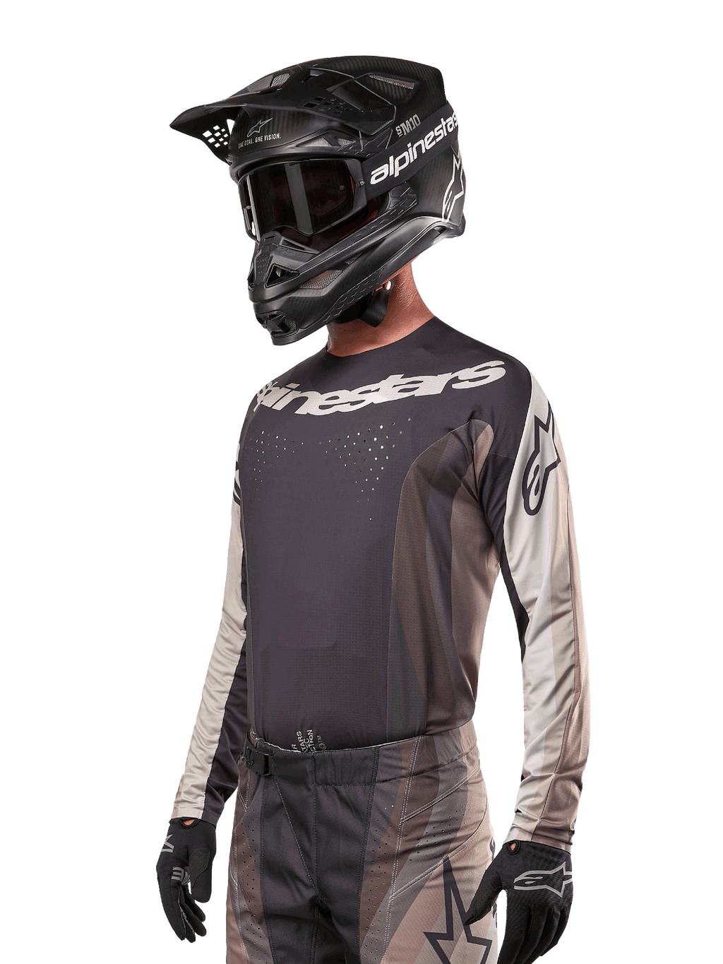 Jersey Alpinestars Techstar Pneuma 2024, camiseta de motocross de manga larga, arena oscura y gris, camiseta técnica con perforaciones láser y logotipos blancos, usada con pantalones a juego y casco negro, ajuste atlético para conducción off-road