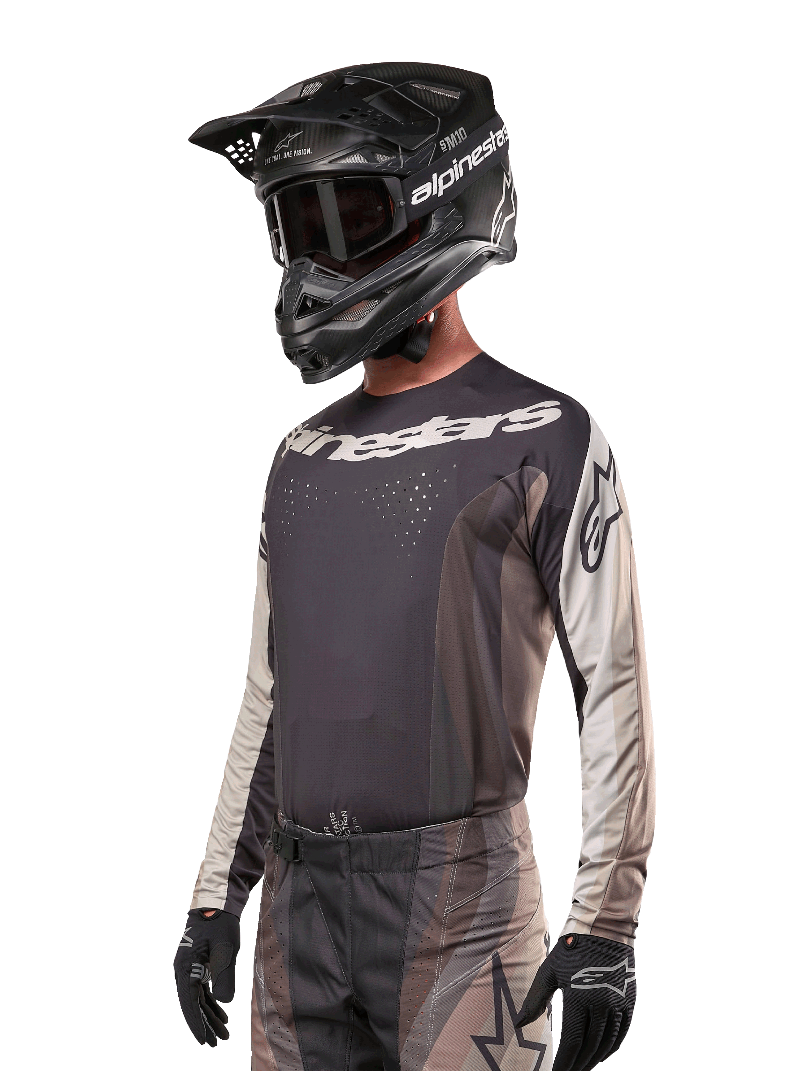 Jersey Alpinestars Techstar Pneuma 2024, camiseta de motocross de manga larga, arena oscura y gris, camiseta técnica con perforaciones láser y logotipos blancos, usada con pantalones a juego y casco negro, ajuste atlético para conducción off-road