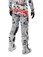 Pantalones Alpinestars Techstar Rantera 2024, pantalones de motocross, Haze Gray Camo con patrones de camuflaje negro y un gran logotipo rojo de Alpinestars en el asiento, vista trasera con botas blancas y equipamiento de carreras a juego