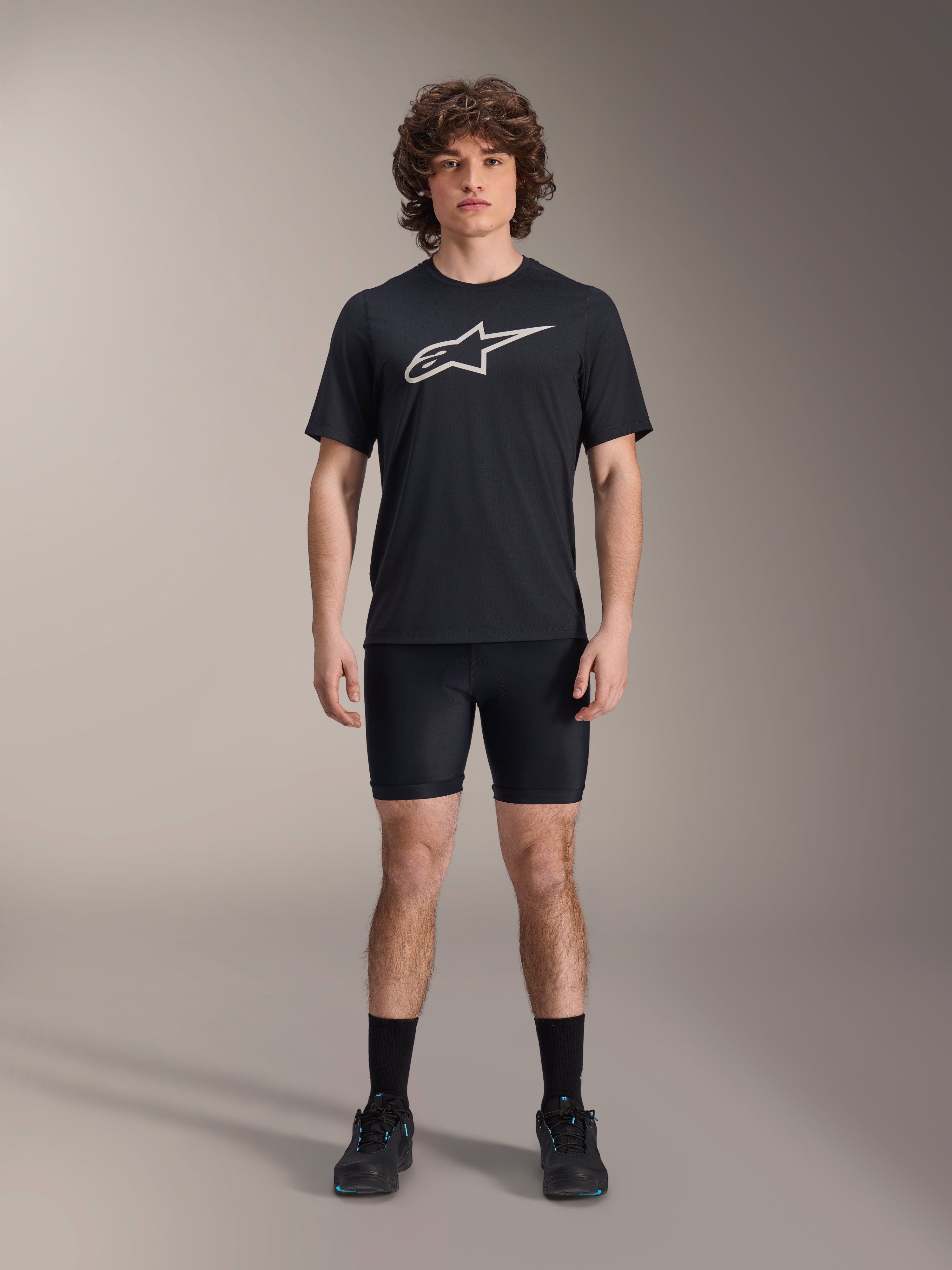 Shorts A-Dura Liner de Alpinestars, shorts interiores de ciclismo negros, vestidos por un modelo con una camiseta negra con el logo de Alpinestars y zapatillas de ciclismo negras, diseño ajustado para rendimiento en MTB y comodidad en el sillín.