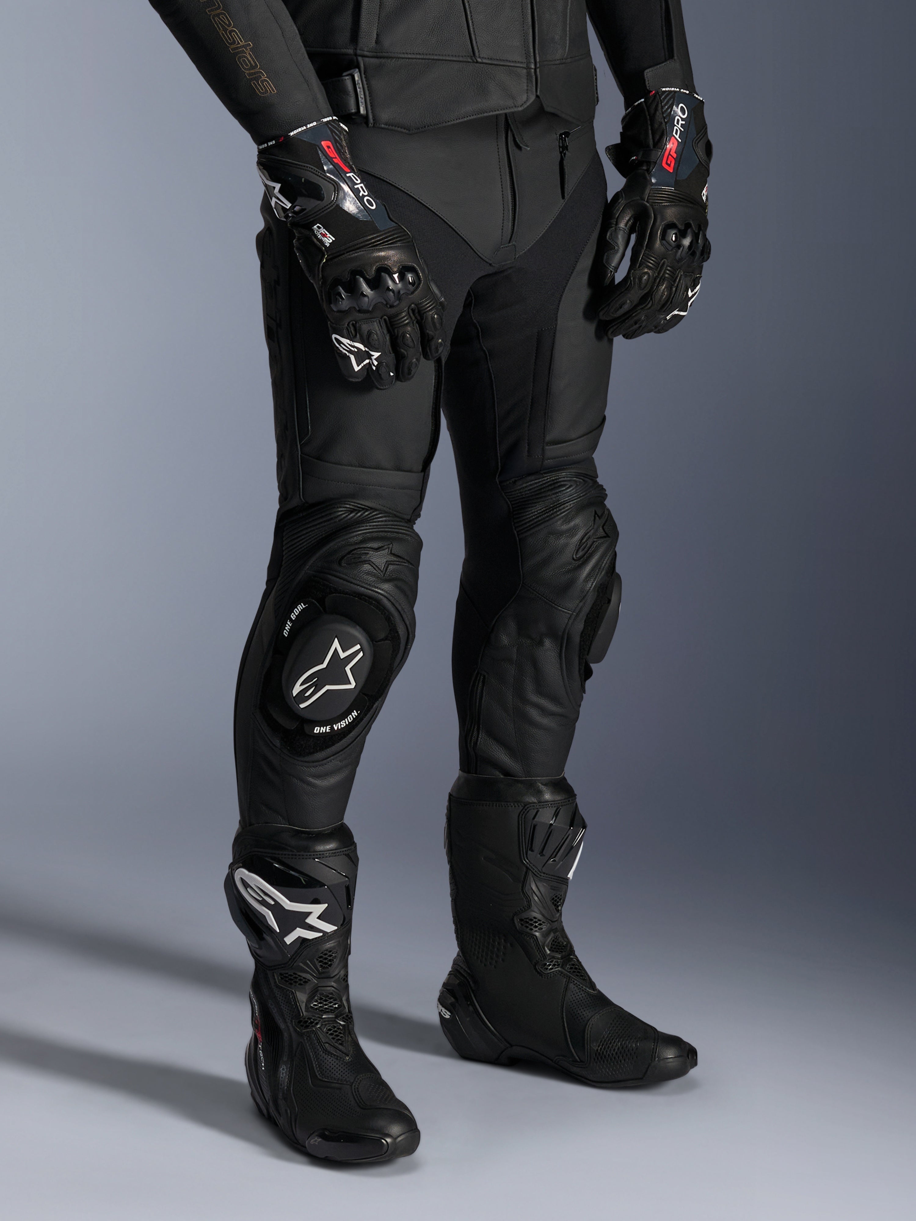 Alpinestars Missile V3 Leather Pants, pantalones negros de carreras para moto, usados con guantes GP Pro a juego y botas técnicas de carreras, construcción de cuero premium con deslizadores de rodilla con logo blanco, estética profesional para pista y carretera