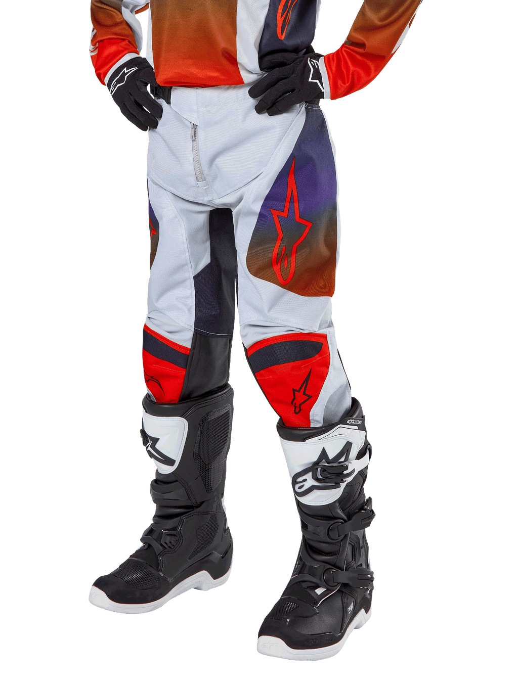 Alpinestars Pantalones Racer Hoen Juveniles 2024, pantalones de motocross, gris claro con detalles en naranja intenso y negro, con logotipos de estrellas rojas en los muslos y paneles rojos en las rodillas, usados con botas negras y blancas, diseño duradero para carreras todoterreno