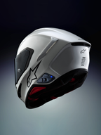 Sistema de comunicación Alpinestars A-Connect instalado en un casco de moto Alpinestars S-R7, blanco y negro, con intercomunicador Mesh 3.0 y unidad de control Bluetooth 5.3 con luz LED azul activa