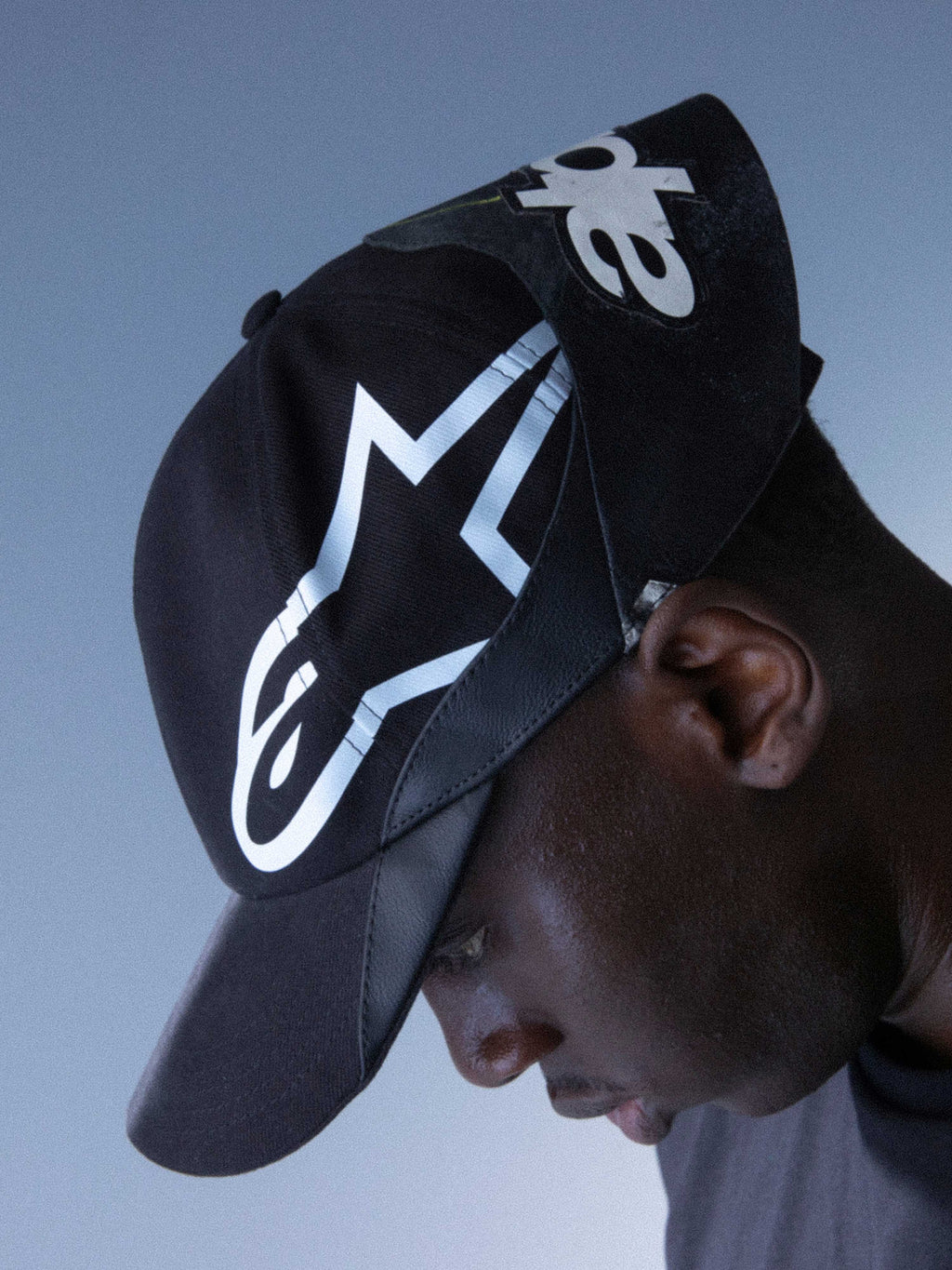 Alpinestars RSRV Resurgence Hat, gorra negra con logo blanco prominente, diseño urbano premium, visera curva, construcción de tela