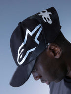 Alpinestars RSRV Resurgence Hat, gorra negra con logo blanco prominente, diseño urbano premium, visera curva, construcción de tela