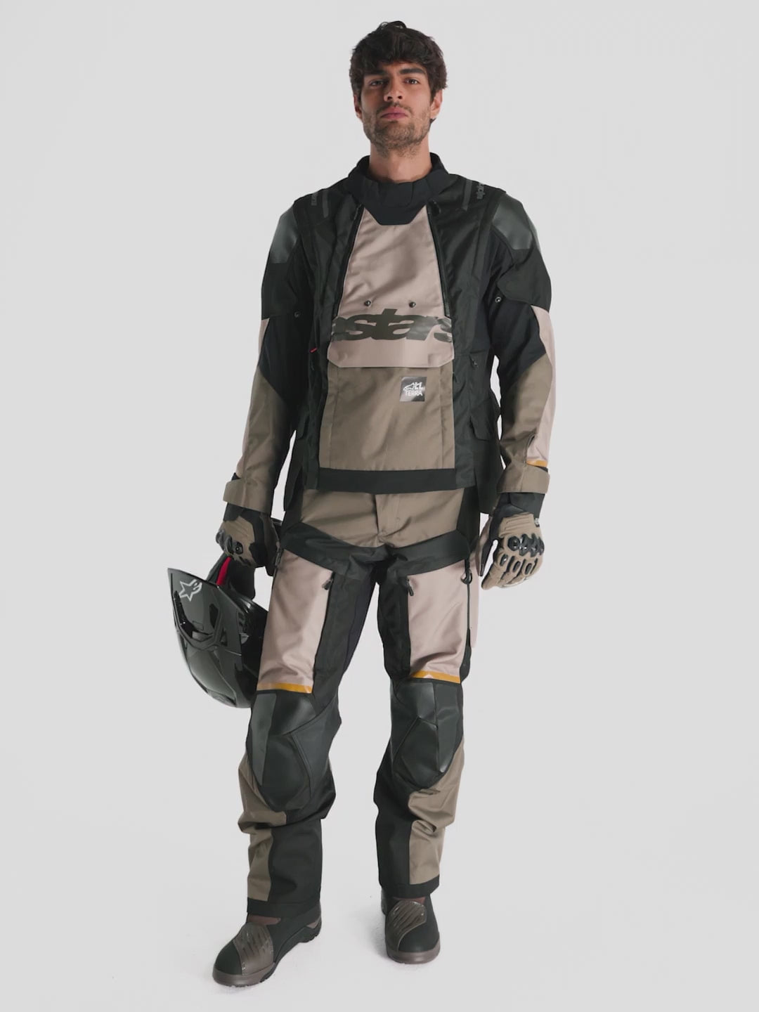 Alpinestars Harok V2 Drystar® Pants, men's adventure touring motorcycle pants in aluminum, walnut, and black, featuring durable ripstop textile, direct thigh ventilation, and CE-certified protection worn by a model.