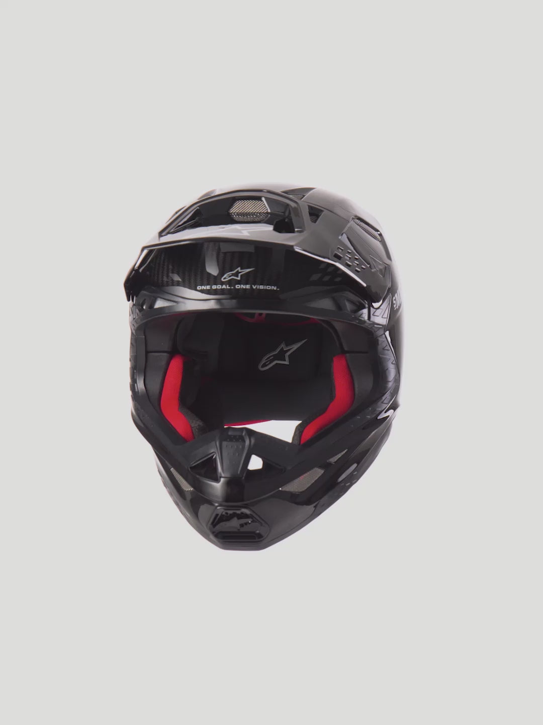 Alpinestars Supertech M10 Solid Helmet ECE 22.06, Black Glossy Carbon Motocross Helmet with red interior padding. High-performance off-road racing protection featuring a 3K carbon shell, MIPS technology, and 28-port ventilation system for maximum airflow.