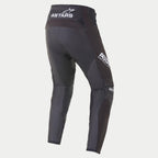 Alpinestars 2021 Techstar Phantom Pants, pantalones de motocross, negro y blanco, vista trasera con el logotipo ASTARS blanco en la cintura y el lateral del muslo, paneles de malla texturizada en color carbón en las piernas y diseño con ajuste de competición de alto rendimiento.